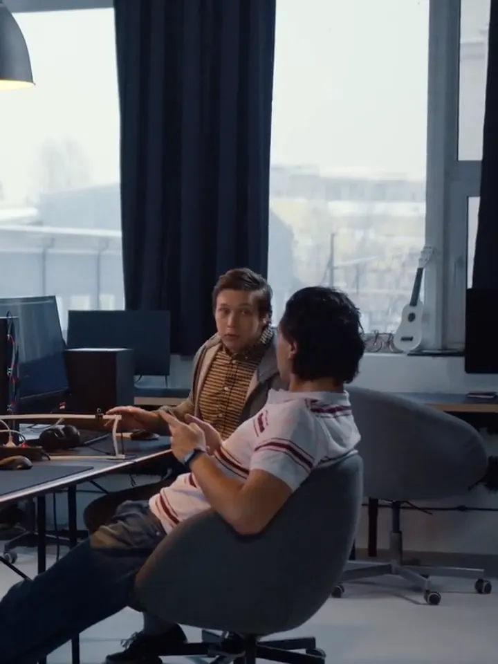 Två kollegor diskuterar ett projekt i studion